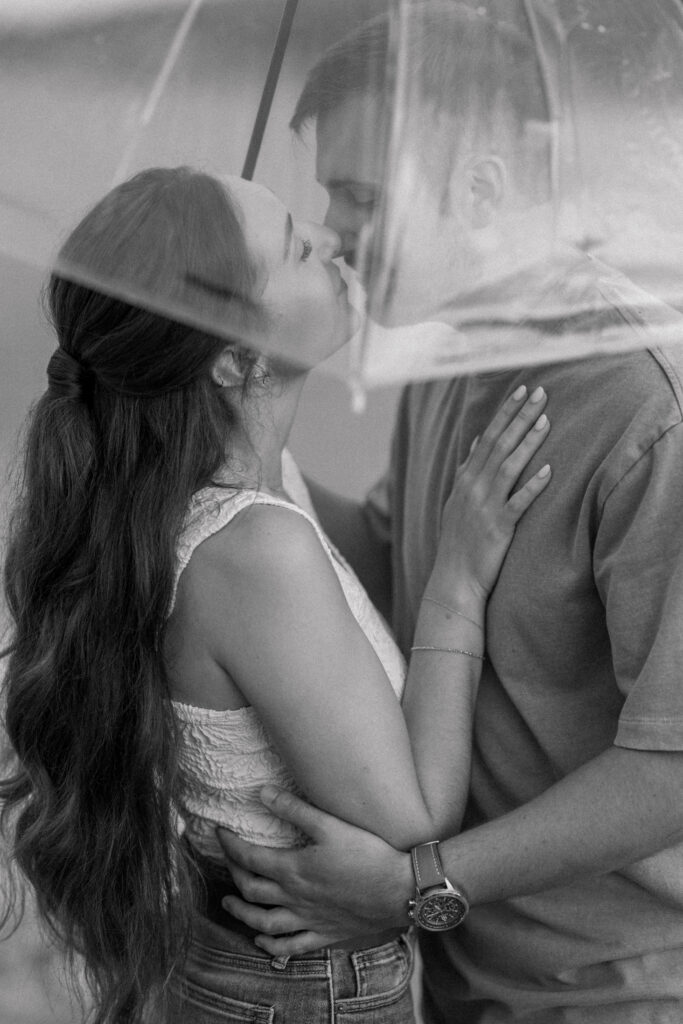 Couple kissing under an umbrella