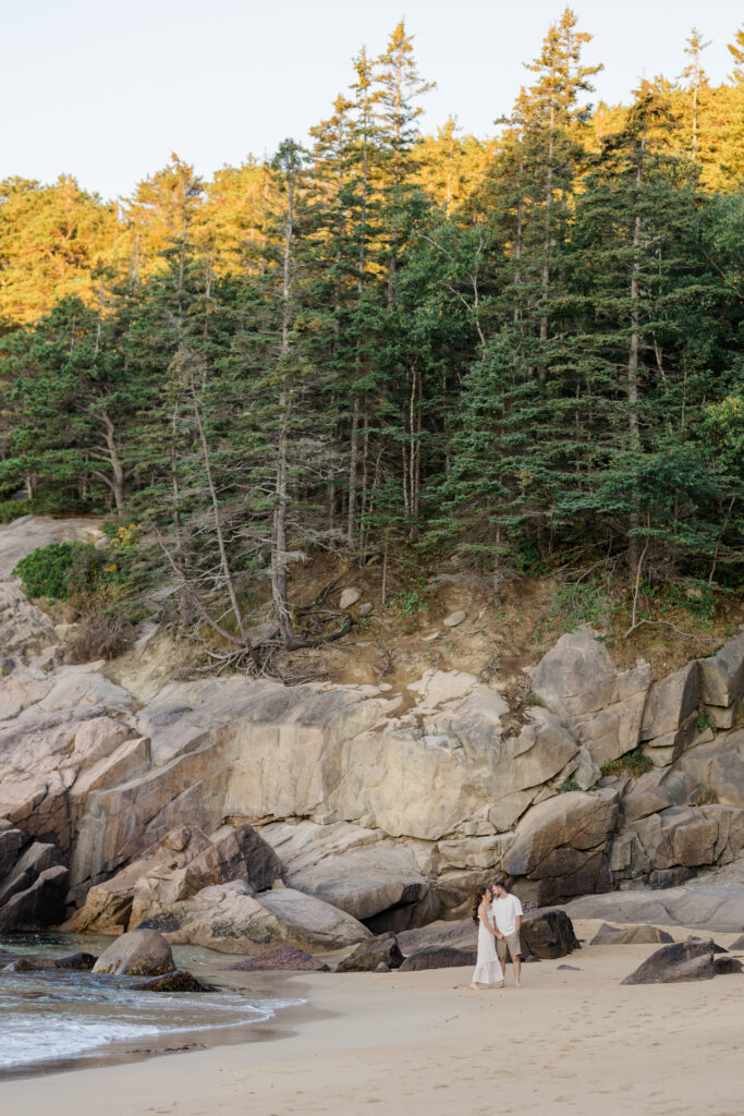 Coastal Engagement Session with rocks behind them